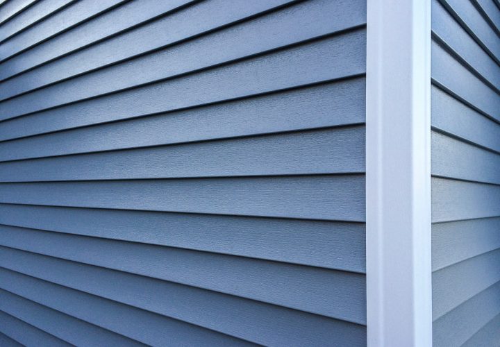 Blue vinyl siding with white trim on the outside wall of a new h